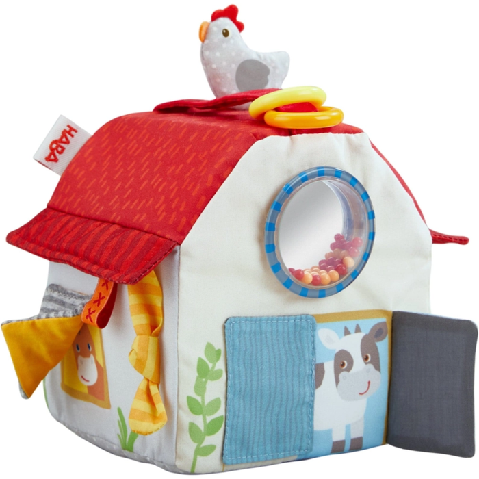 Soft farm-themed play cube with red roof, peek-through rattle window, flaps, textures, and a plush chicken on top.