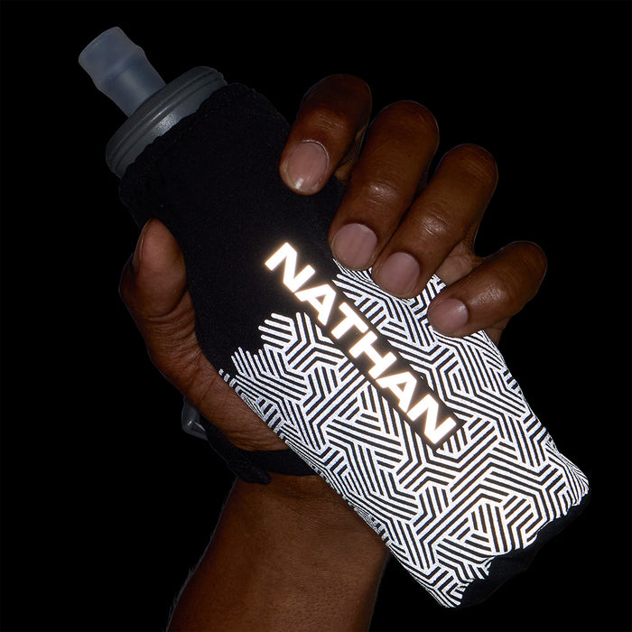 color:Black/Hex Print||seo:HyperNight Pinnacle 14oz Soft Flask - Black/Hex Print -Model Gripping Handheld Flask - Front View at Night