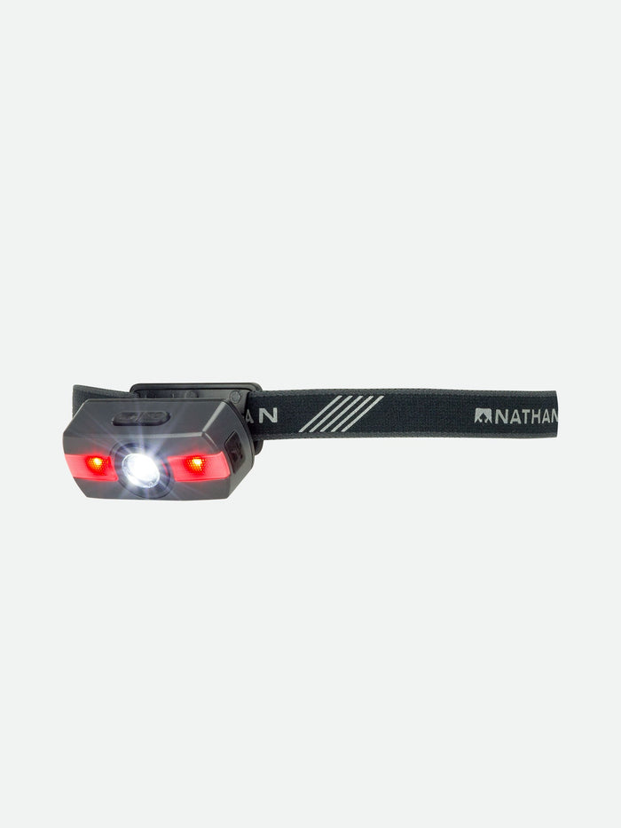 color:Charcoal||seo:Nathan Neutron Fire RX 2.0 Runner's Headlamp – Charcoal Grey – Three Quarter View - Headlamp Tilted Down (Red Light On)