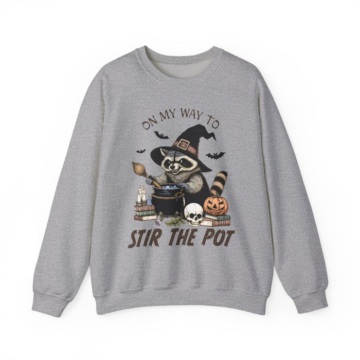 light pink sweatshirt with raccoon witch stirring cauldron halloween design