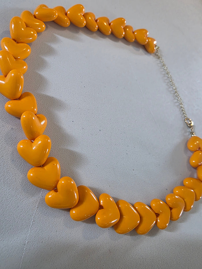 orange heart jewellery necklace on model showcasing wearable size