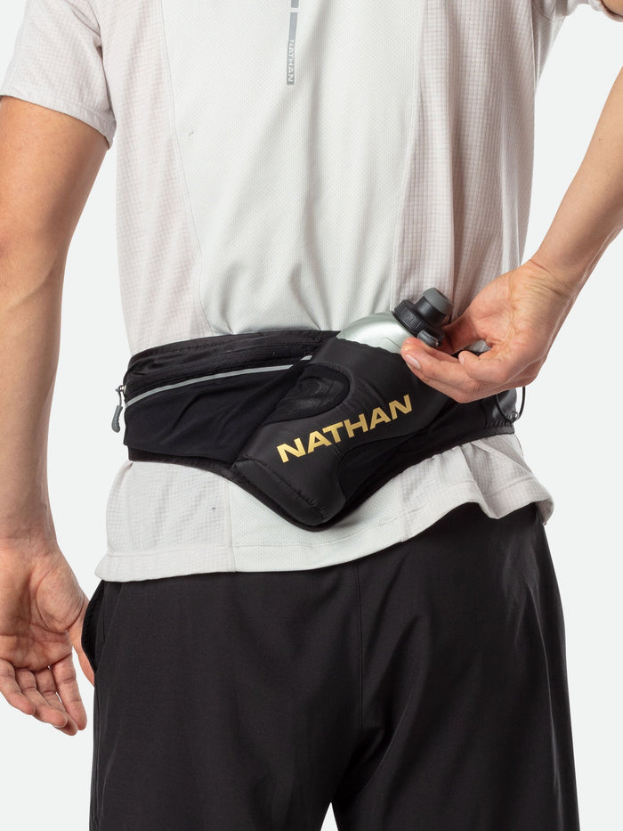 color:Black/Gold||view:sku image back||seo:Nathan Peak Hydration Waist Pack - Black/Gold - On Model - Runner Pulling Out Bottle From Pack
