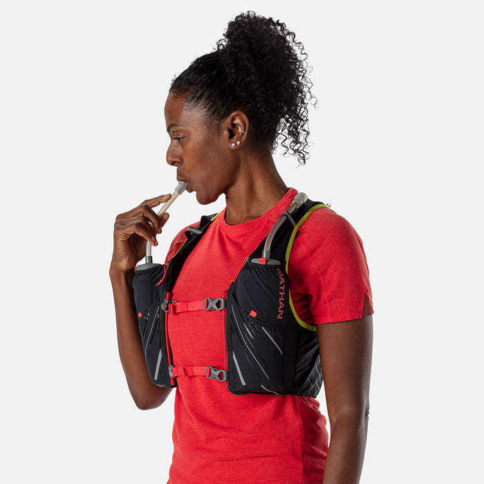 color:Black/Hibiscus||seo:Nathan Pinnacle 4 Liter Women's Hydration Race Vest - Black/Hibiscus Red - Female Runner Sipping Water from Front Flask