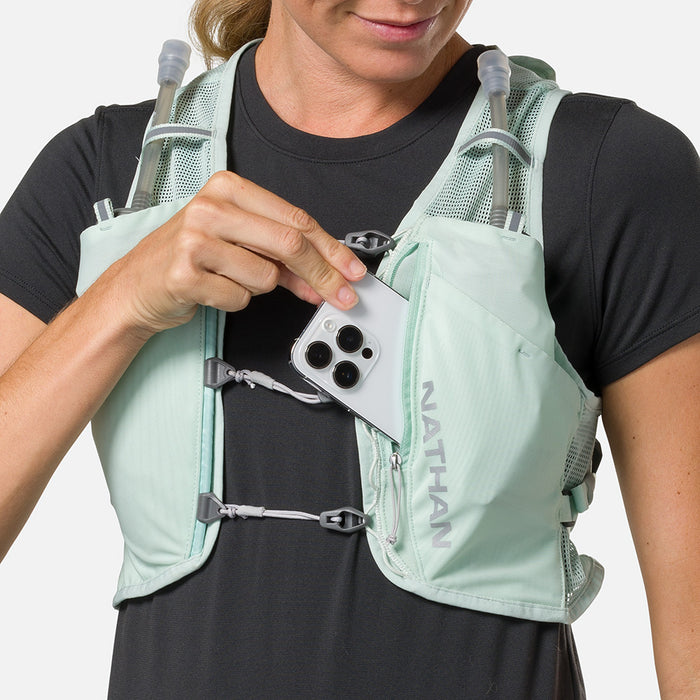 color:Surf Spray/Reflective Silver||seo:Nathan Pinnacle Breeze 4 Liter Women's Hydration Race Vest - Surf Spray/Reflective Silver - Model Pulling iPhone from Front Pouch