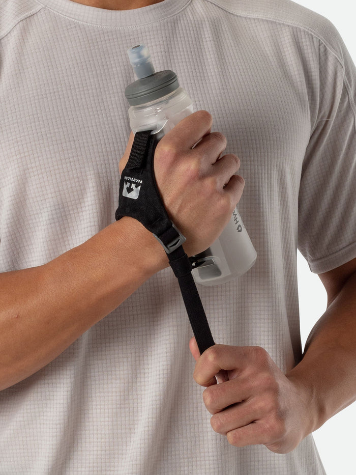 color:Clear||seo:Nathan Pinnacle Lite Handheld 14oz - Clear - Runner Pulling Strap to Tighten Handheld Around the Palm