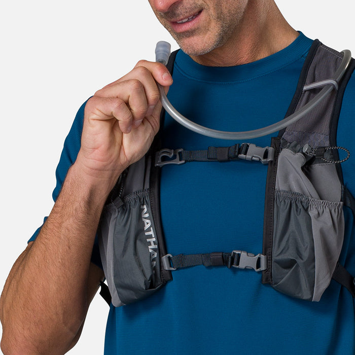 color:Charcoal/Reflective Silver||seo:Nathan TrailMix 2.0 12 Liter Unisex Hydration Pack - Charcoal/Reflective Silver - Male Runner Taking Sip of Water From Bladder Hose