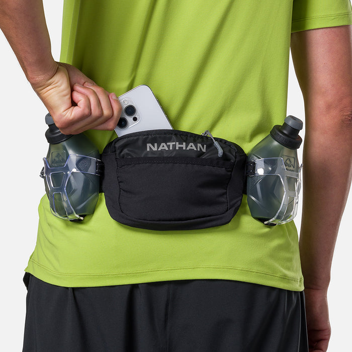 color:Black/Reflective Silver||seo:Nathan TrailMix Plus Hydration Belt 3.0 - Black/Reflective Silver - On Model - Pulling Cell Phone From Pocket