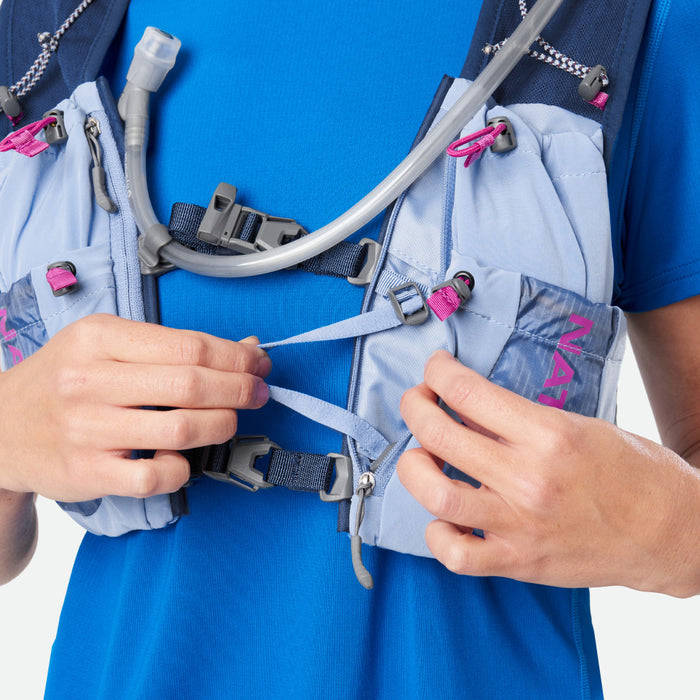 color:Periwinkle/Magenta||seo:Nathan VaporAiress 3.0 7 Liter Women's Hydration Pack - Periwinkle/Magenta - On Model - Model Tightening Straps on Front of Vest