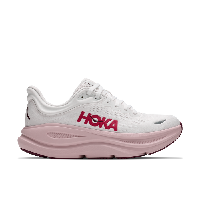 A white HOKA running shoe with a thick, cushioned light pink sole and a bold pink HOKA logo on the side, shown against a plain white background.